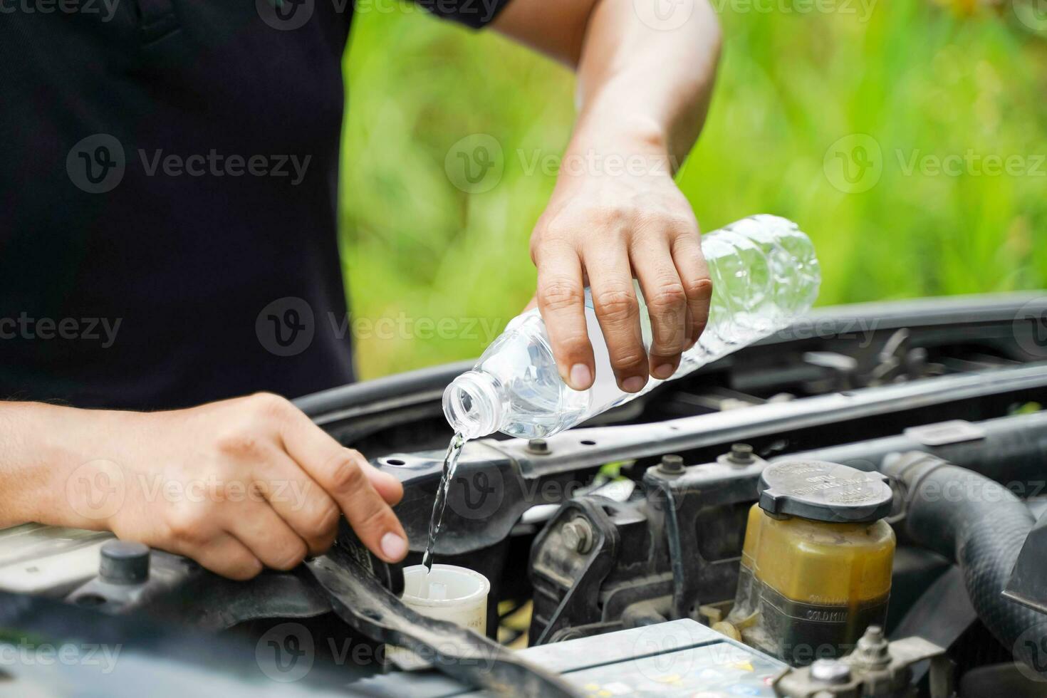 de cerca y cosecha imagen de mano de humano comprobación coche motor y relleno agua a el coche radiador en borroso antecedentes. foto