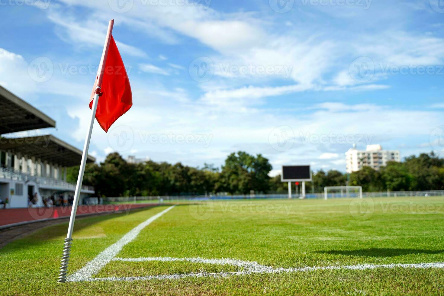 Closeup red flag in a football ground corner with bright blue sky. photo