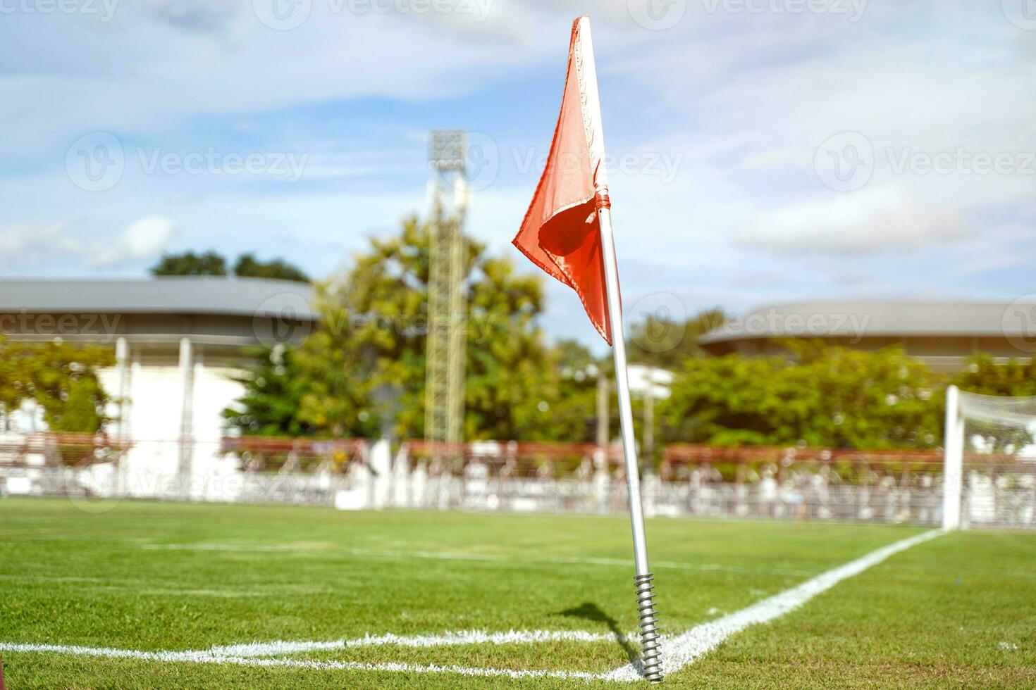 Closeup red flag in a football ground corner with bright blue sky. photo