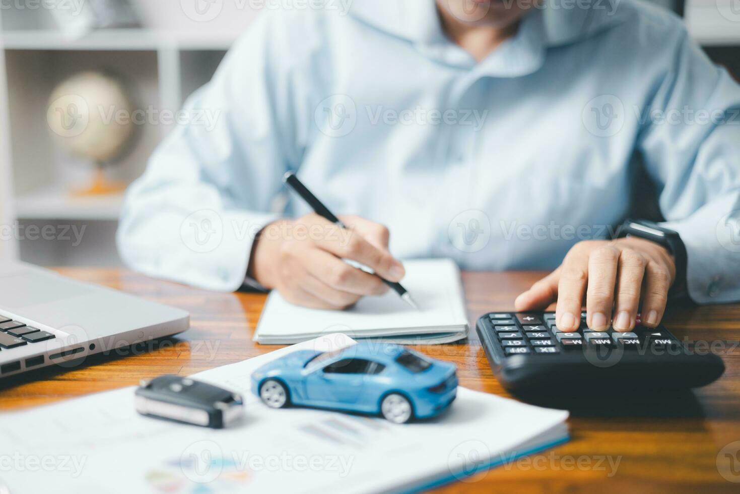 Toy Car In Front Of Businessman Calculating Loan. Saving money for car concept, trade car for cash concept, finance concept. photo