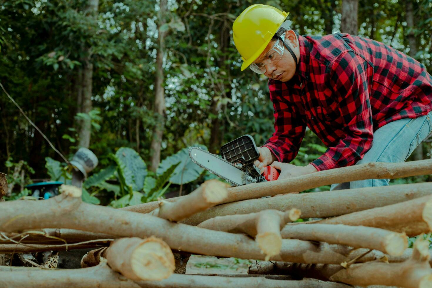 un granjero es utilizando un cadena Sierra a cortar leña. foto