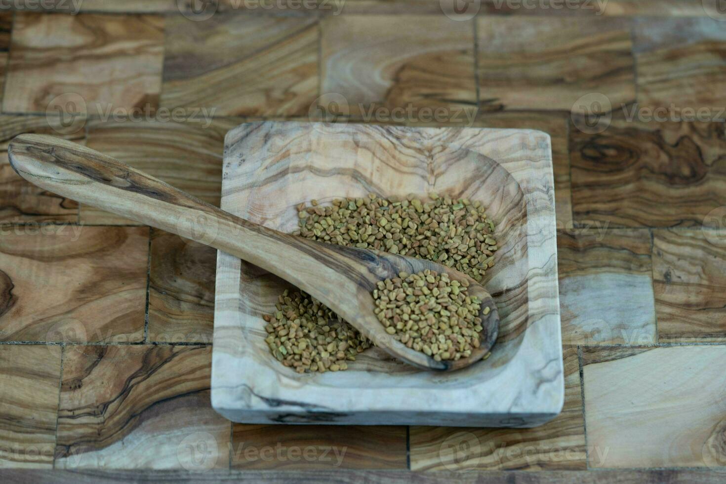 Fenugreek seeds whole or ground on olive wood photo