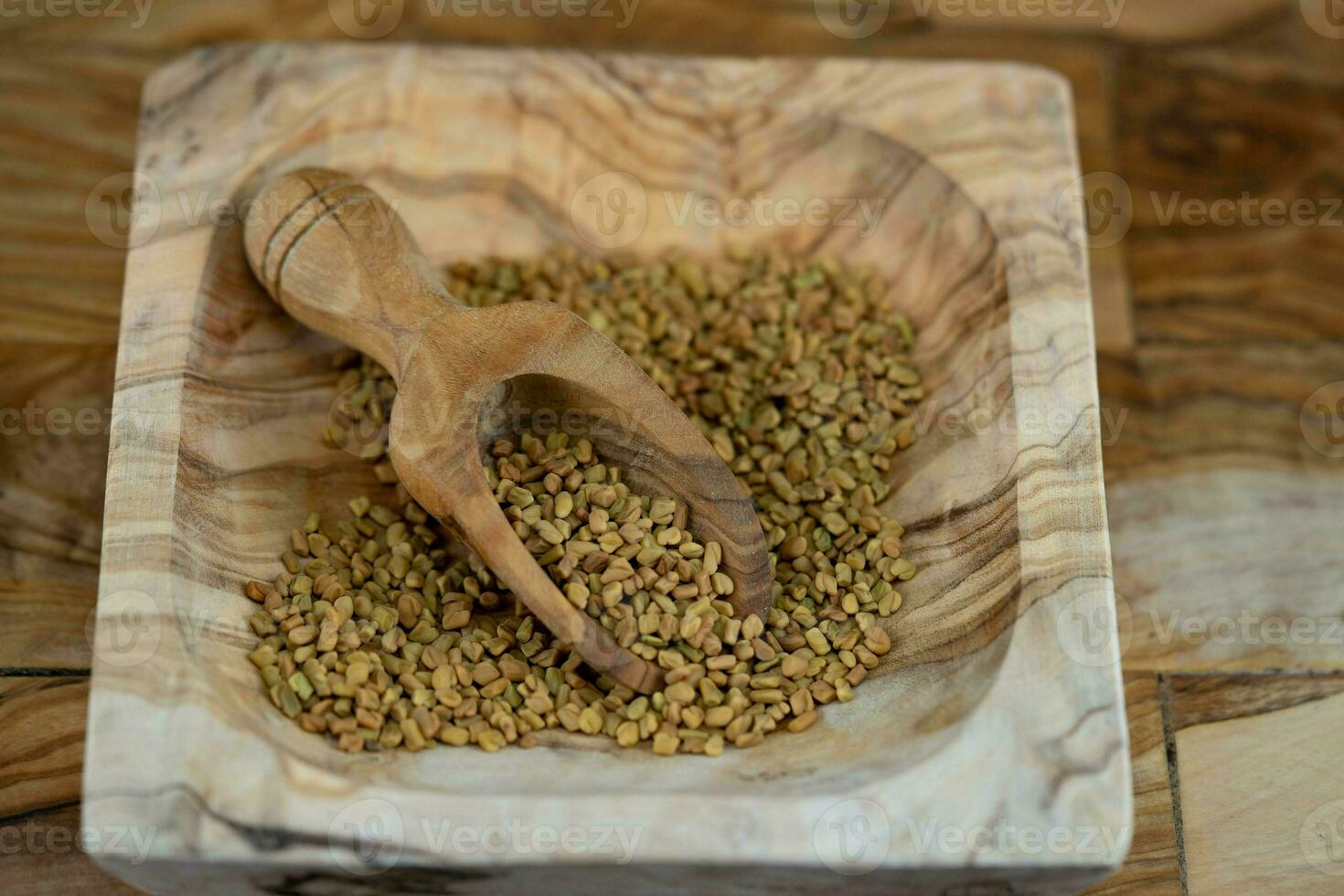 Fenugreek seeds whole or ground on olive wood photo