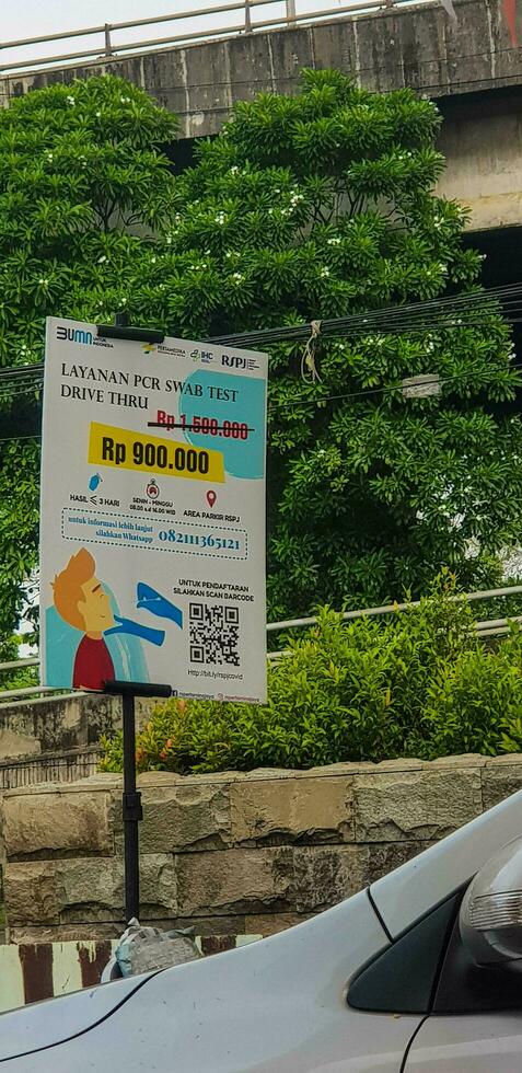 Jakarta, Indonesia on August 8 2019. A small banner regarding the price of the PCR Swab Test Drive Thru Service photo