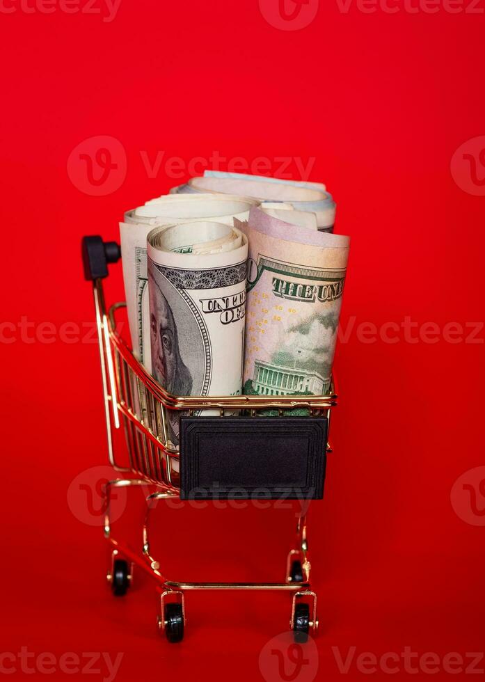 Dollars on a red background. Banks and financial concept. American currency, cash. Money in a cart. photo