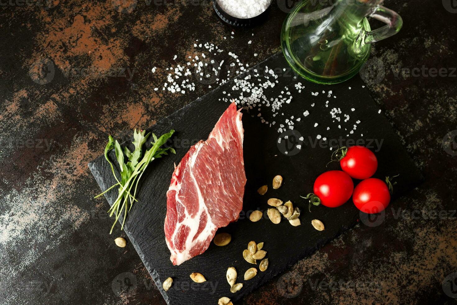 cerdo crudo con especias para cocinar al fuego o al horno sobre un fondo de piedra oscura foto