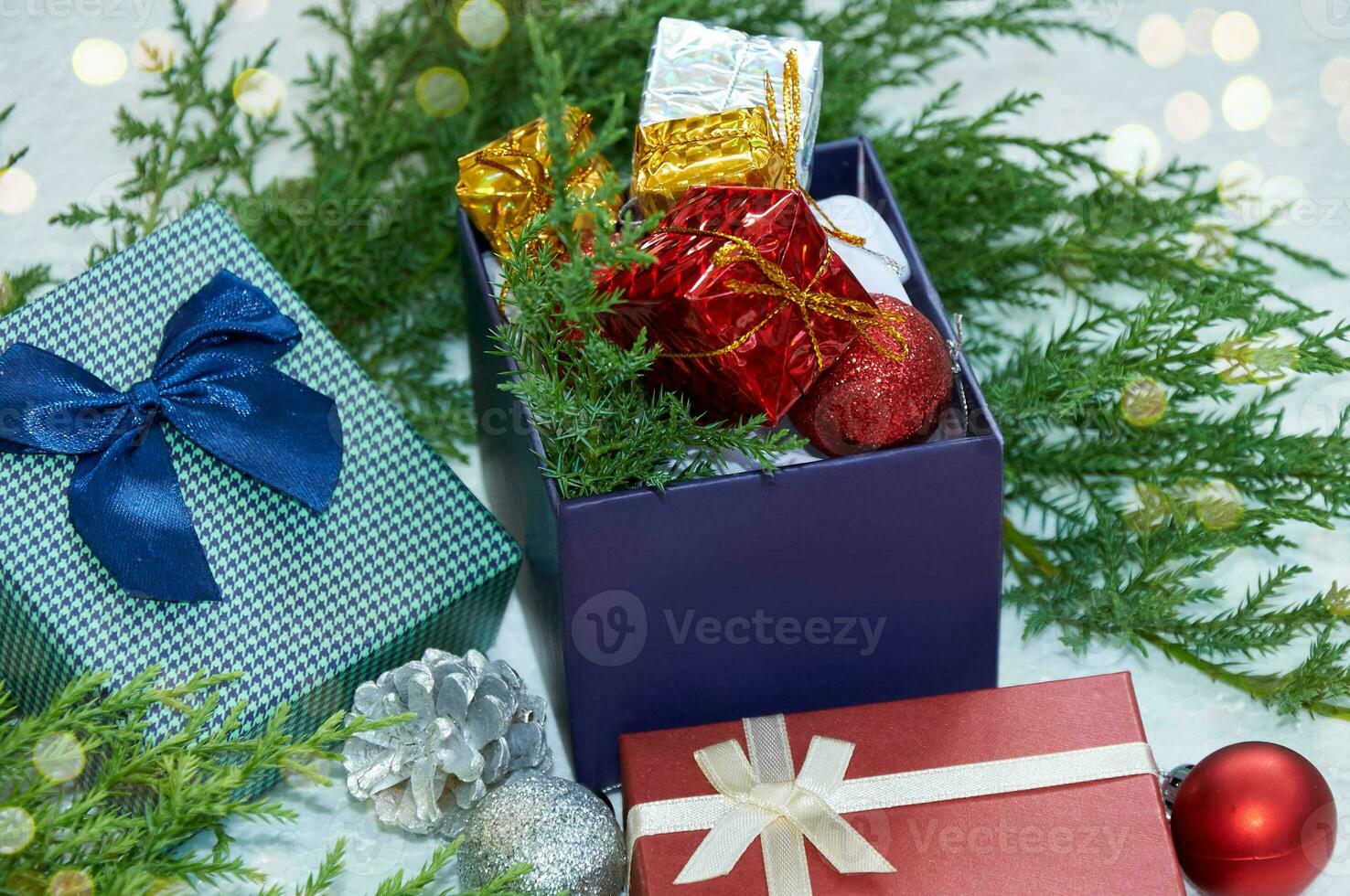 Christmas composition with Christmas tree branches, red tinsel, gift boxes and silver tinsel photo