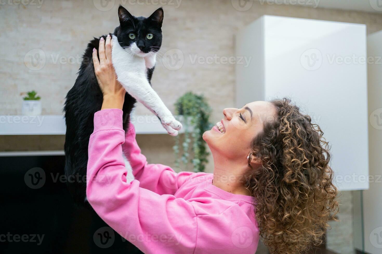 Happy young woman spending time playing with cute cat photo