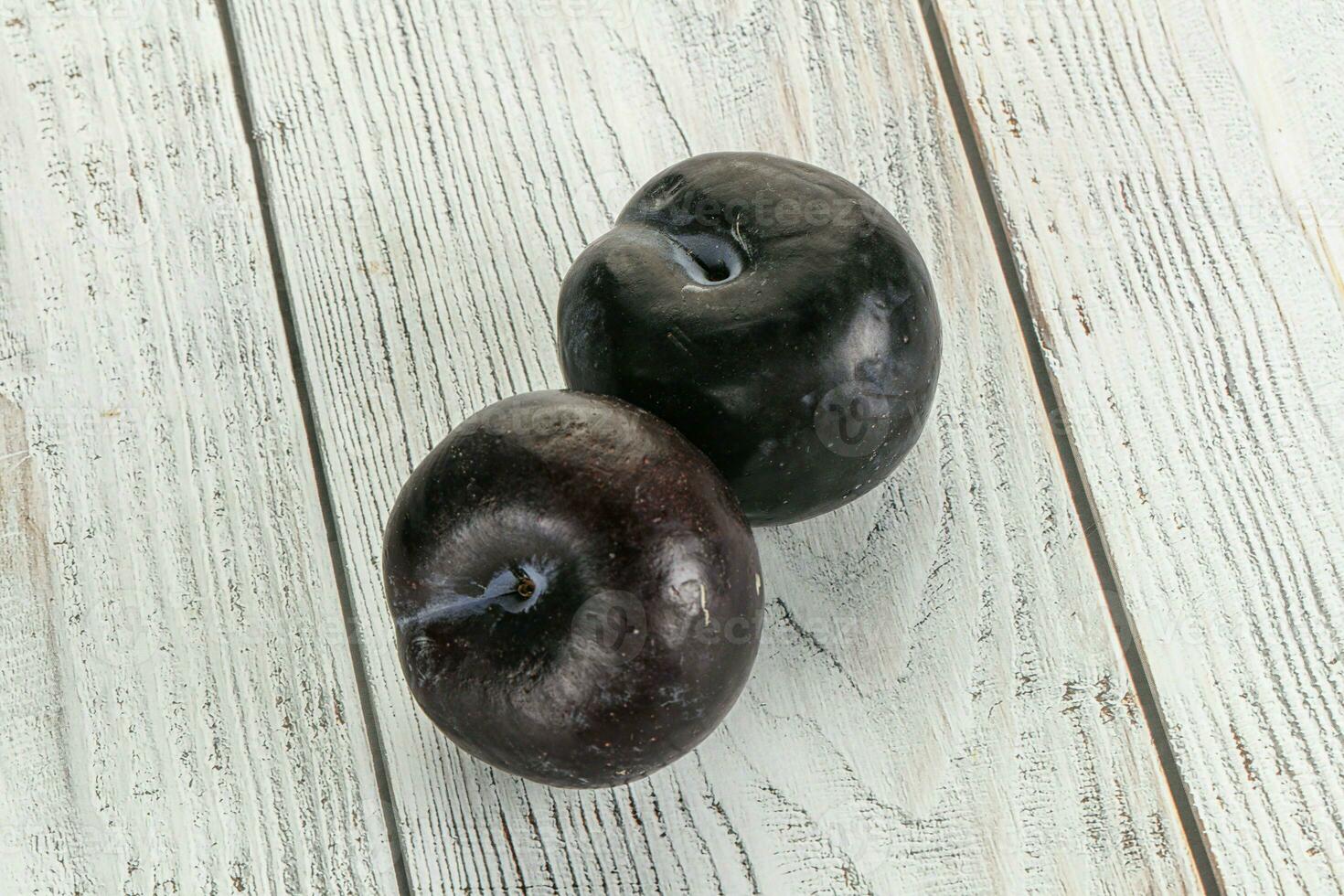 Two ripe sweet black plums photo