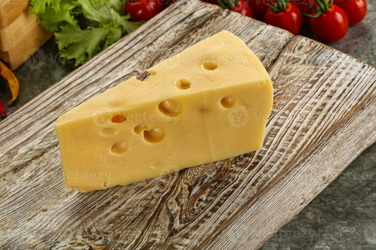 Swiss Maasdam cheese triangle over board photo