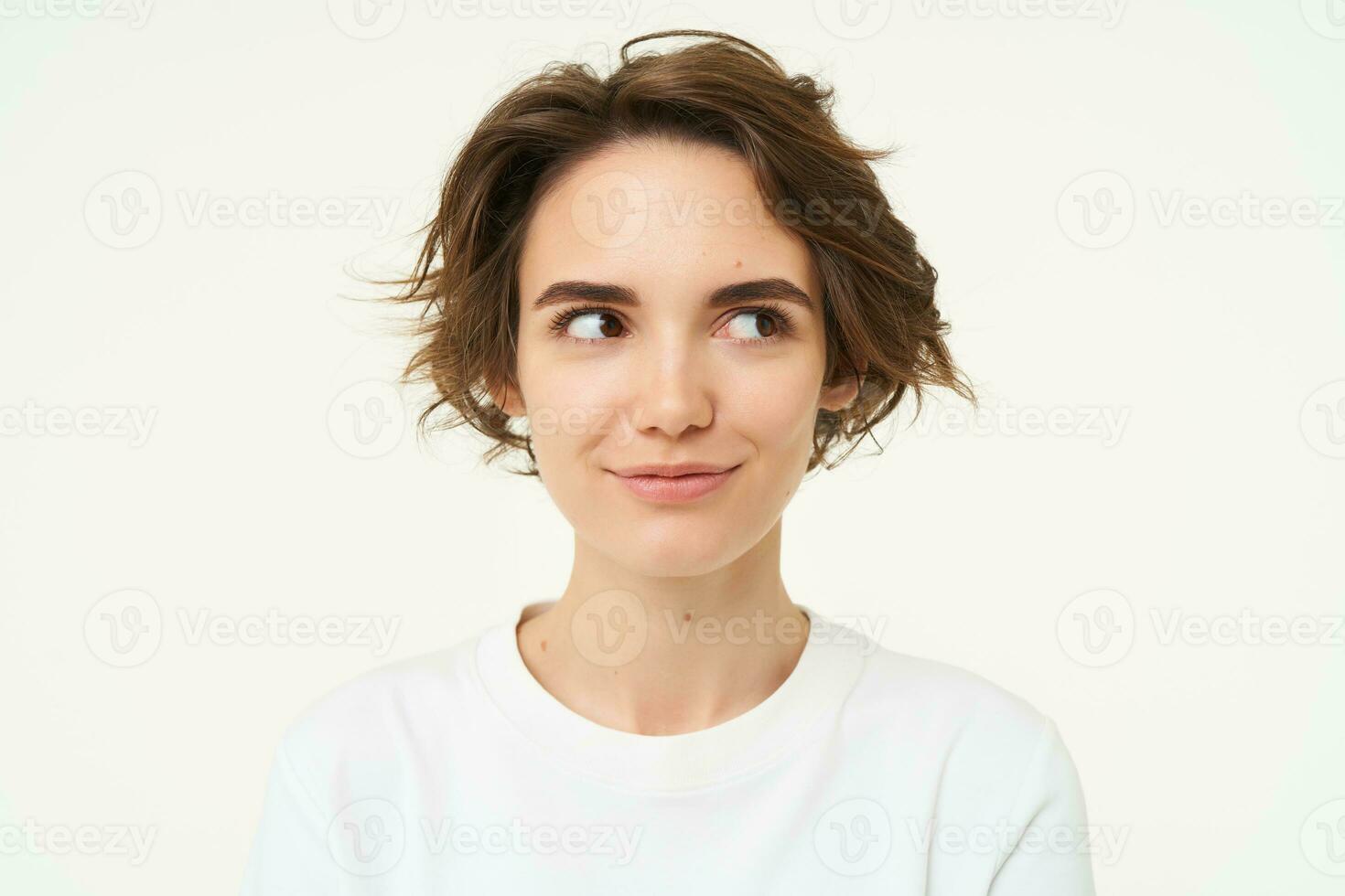 Close up portrait of brunette girl with short haircut, smiling and looking happy, posing over white background photo