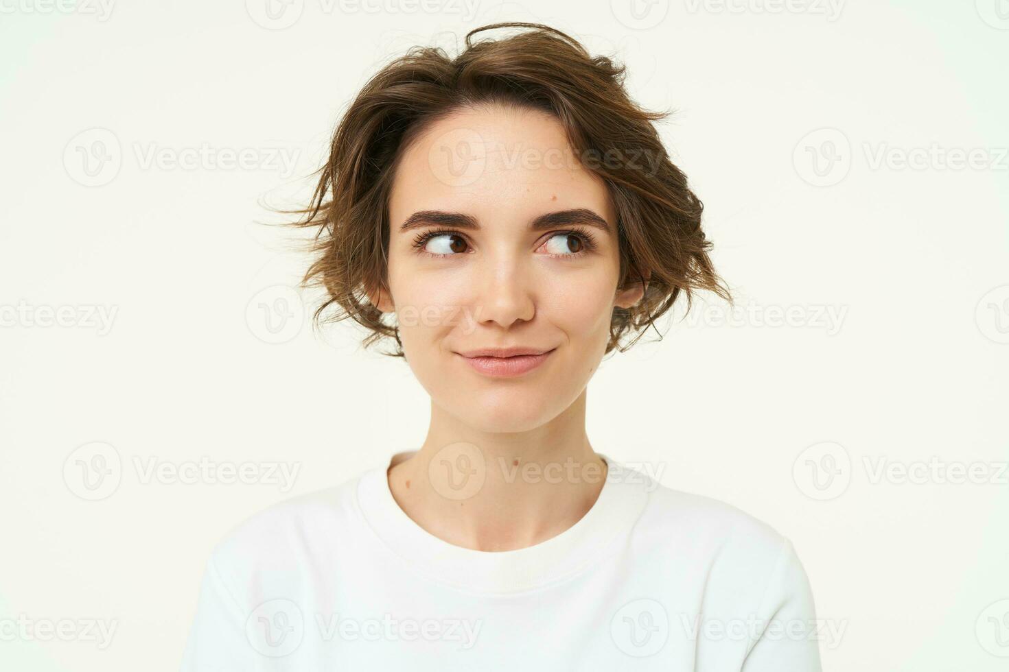 cerca arriba retrato de morena niña con corto Corte de pelo, sonriente y mirando feliz, posando terminado blanco antecedentes foto