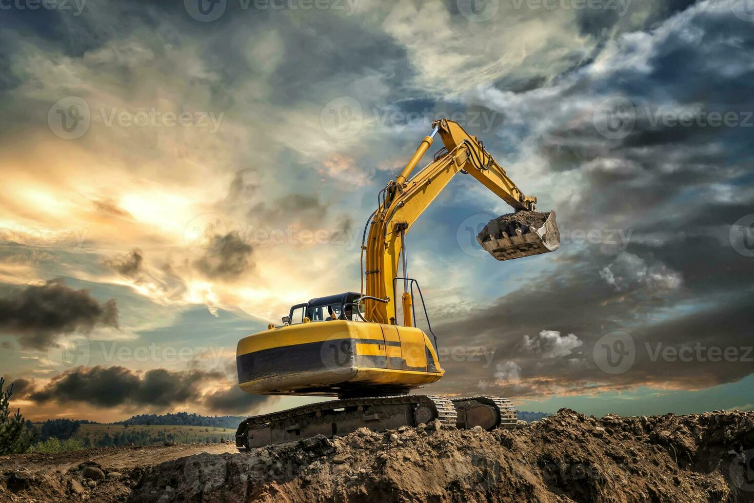 Crawler excavator during earthmoving works on construction site at sunset photo