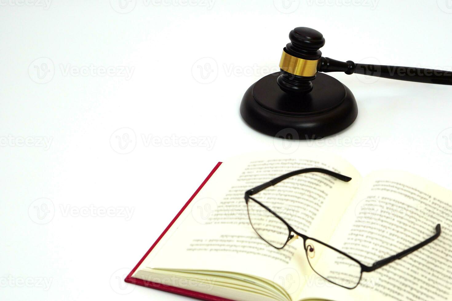 cerca arriba juez mazo o martillo metido detrás y borroso lentes con ley libro. ley, judicial concepto. foto