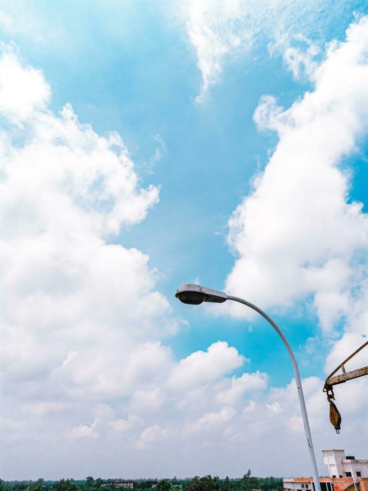 un azul cielo con nubes y un calle ligero foto