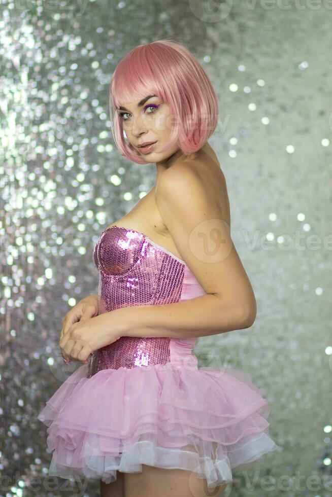 Woman in a pink wig with short hair on a silver shiny background photo