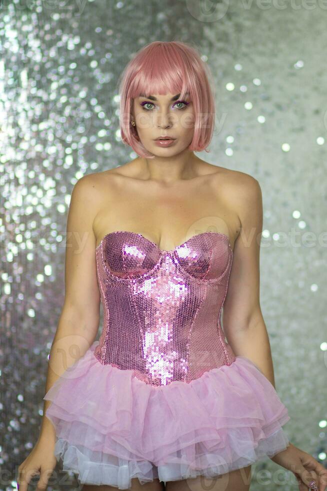 Woman in a pink wig with short hair on a silver shiny background photo