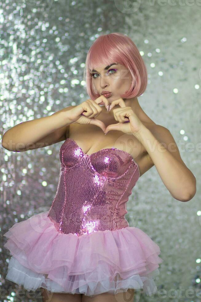 Woman in a pink wig with short hair on a silver shiny background photo