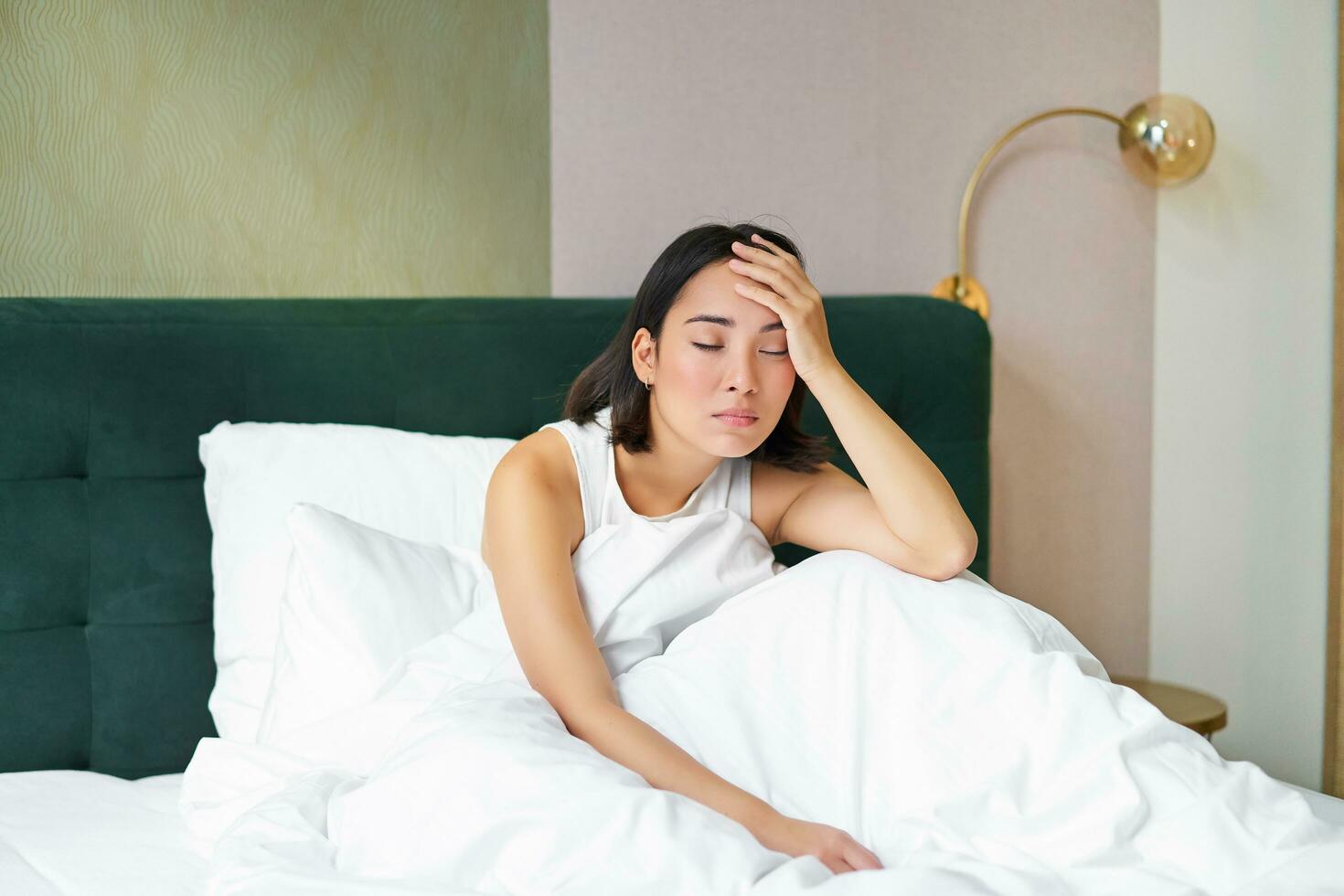 retrato de triste joven mujer despertar arriba, sensación malo, quiere a dormir, despierta temprano mañana, mirando perezoso y trastornado foto