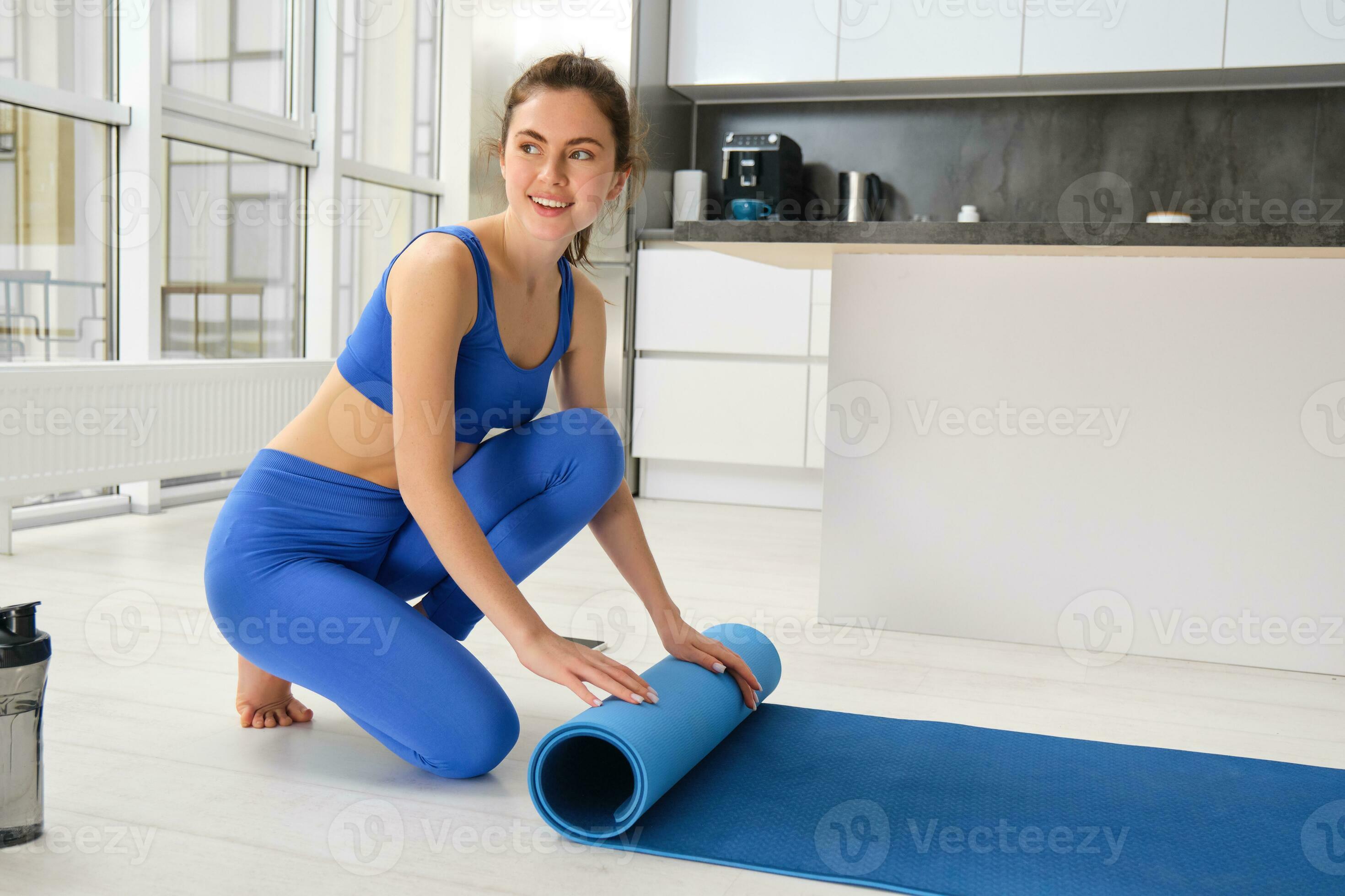 Portrait of beautiful fitness girl preparing yoga mat, unwrapping for  exercises at home, setting up equipment for workout training in living room  35339315 Stock Photo at Vecteezy