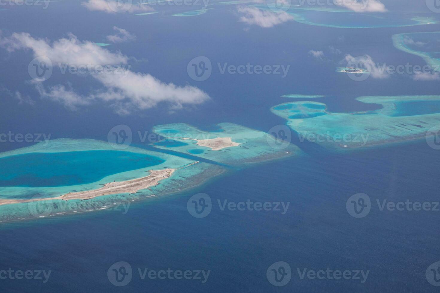 Aerial view on Maldives island atolls. Tropical islands lagoon in Maldives from aerial photography Summer exotic vacation holiday landscape background. Seaplane flying above travel landscape photo