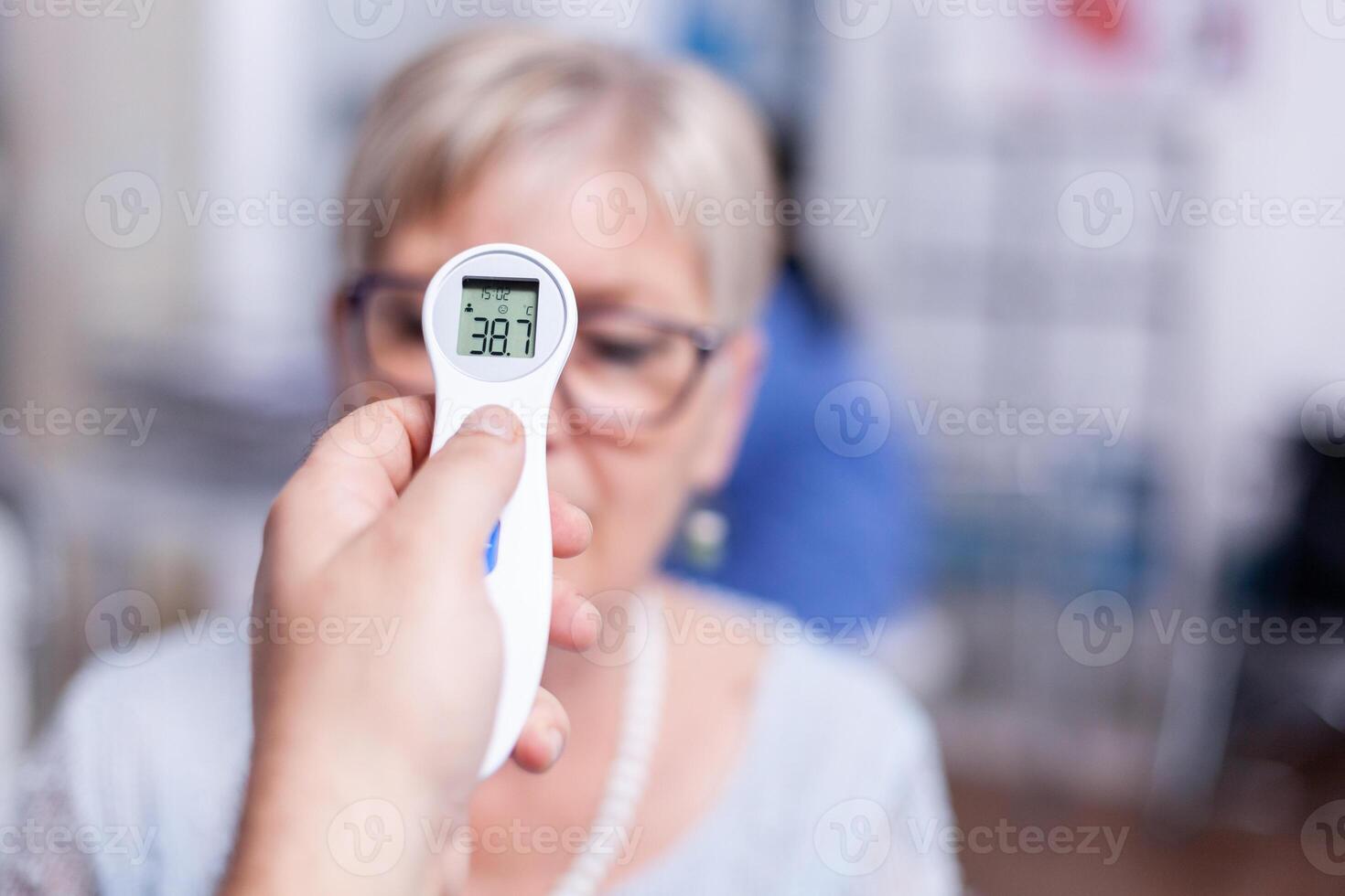 Reading body temperature using infrared thermometer during medical examination. Consultation for infections and disease during global pandemic, flu, tool, sickness. photo