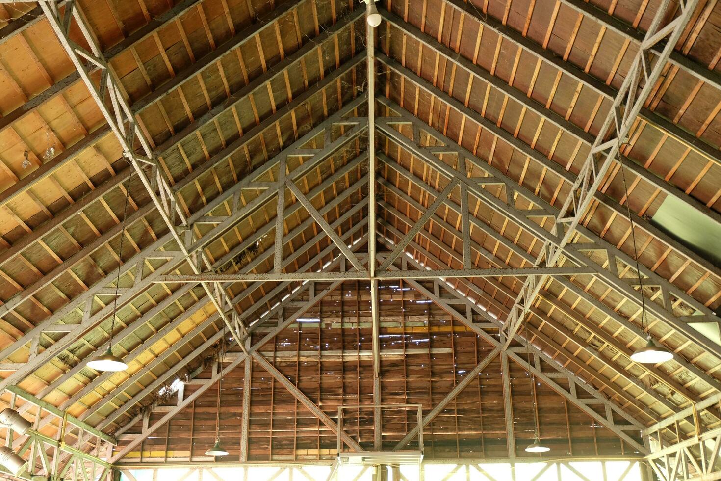 An old building with a gable-shaped wooden and steel roof structure. photo