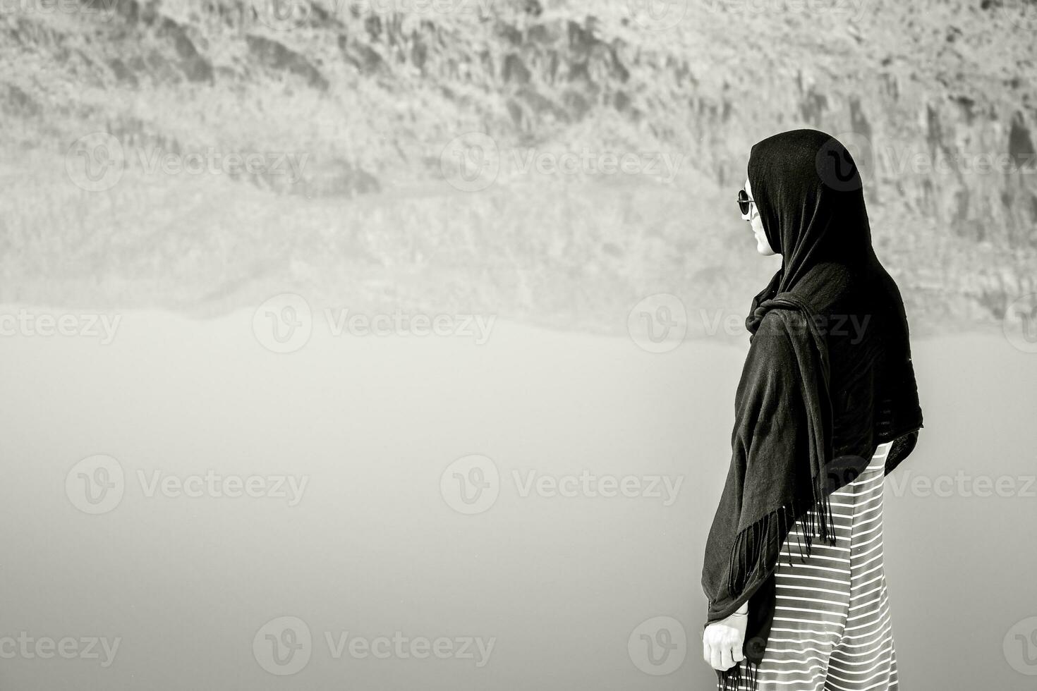 Caucasian woman watch Maharlu pink salt lake reflections mountains panorama in Shiraz, Iran photo