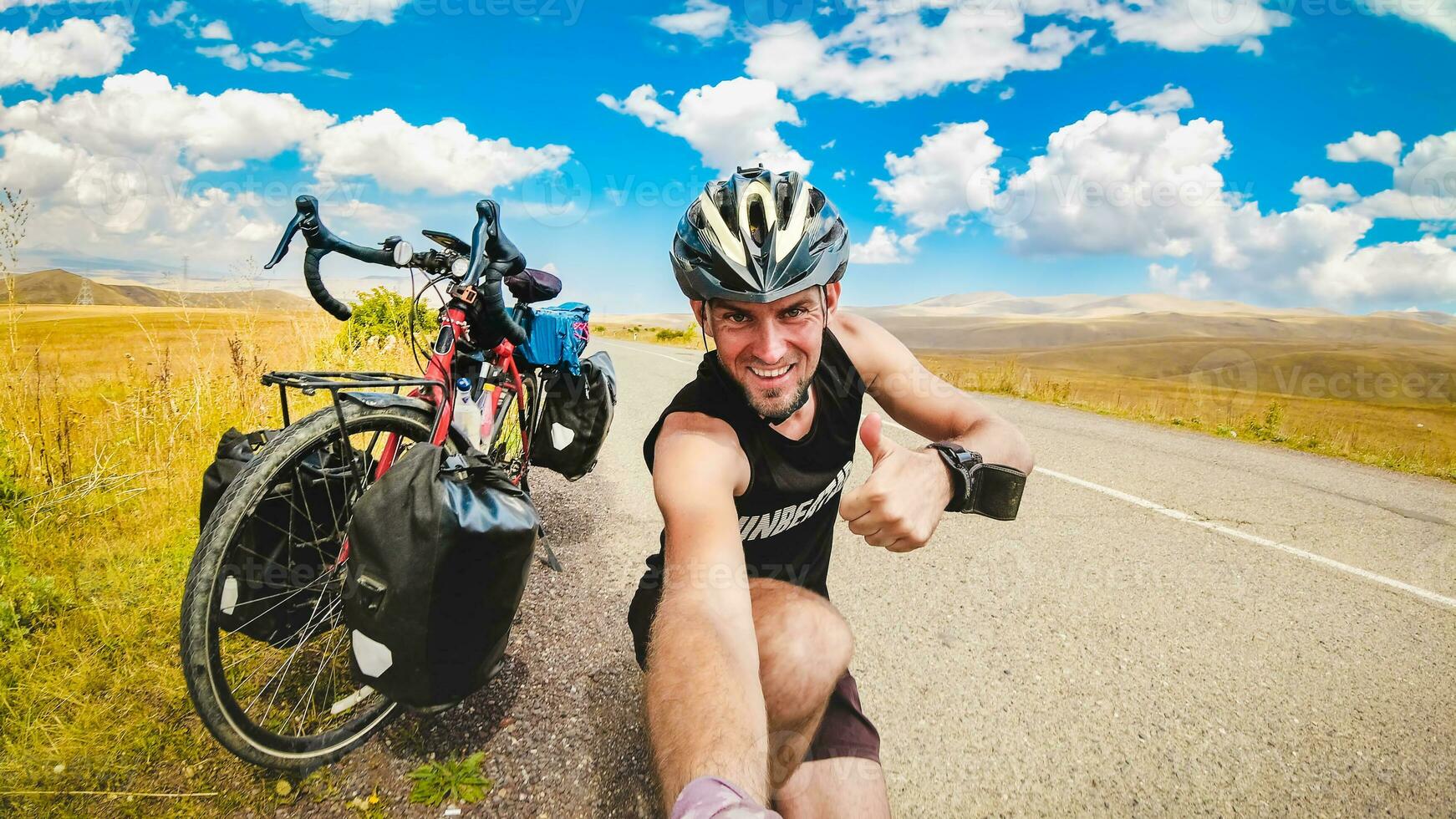 Male person takes a selfie on bicycle vacation in scenic caucasus mountain region. Travel bicycle touring concept. photo