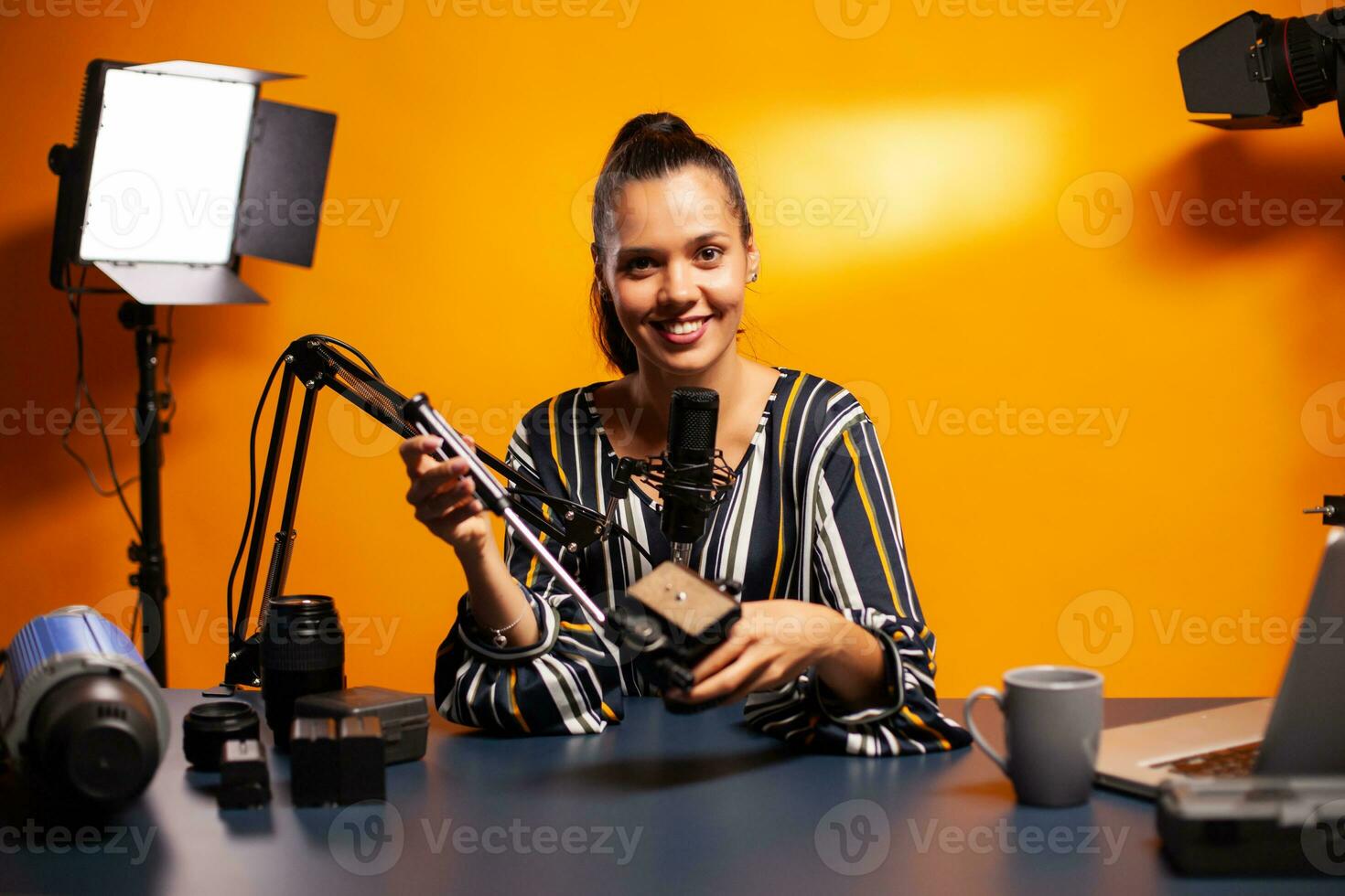 Holding videography equipment and recording podcast. Social media star making online internet content about video equipment for web subscribers and distribution, film photo