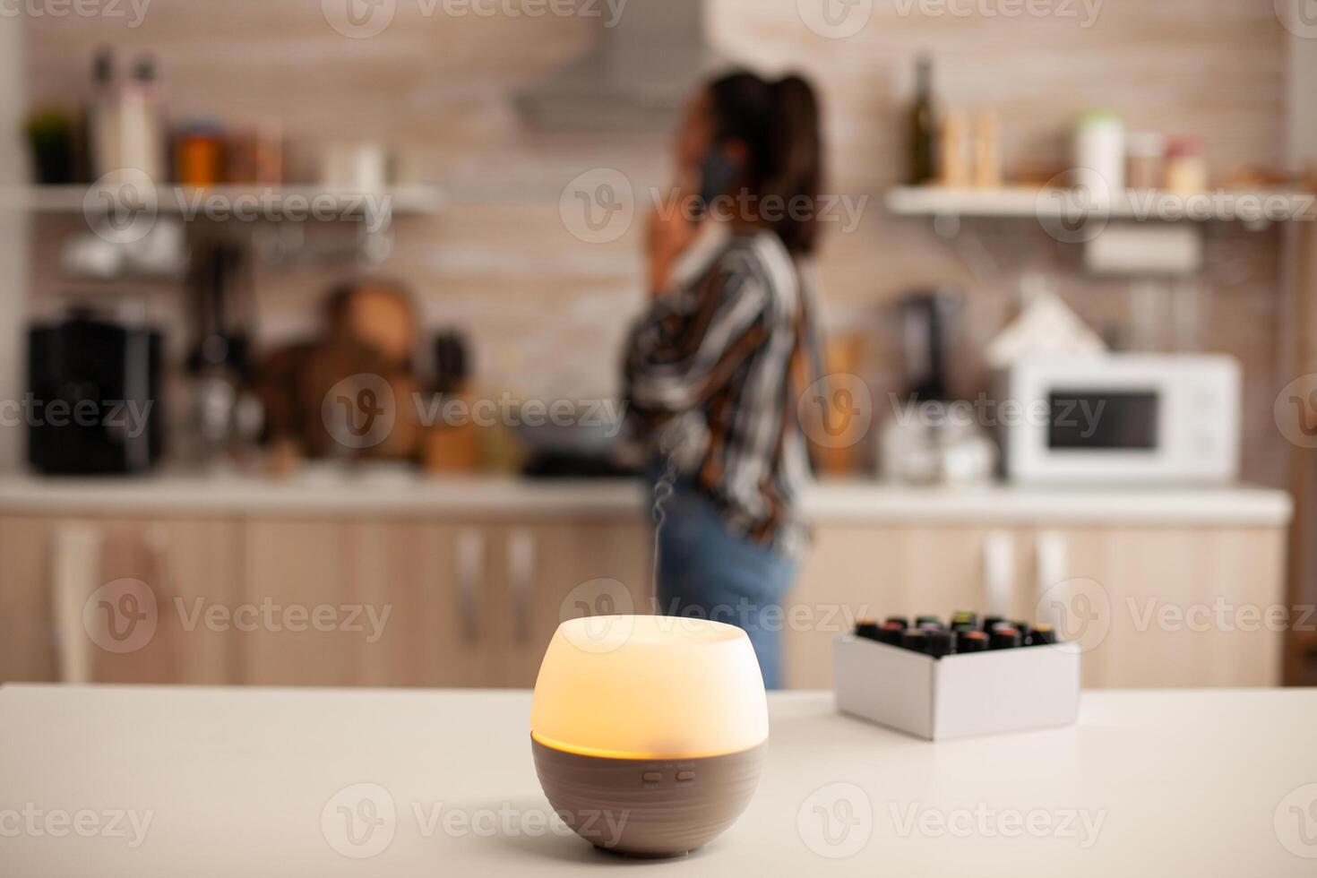 Having a conversation unsing smartphone and ejoying aromatherapy from diffuser with essential oils. Aroma health essence, welness aromatherapy home spa fragrance tranquil theraphy, photo