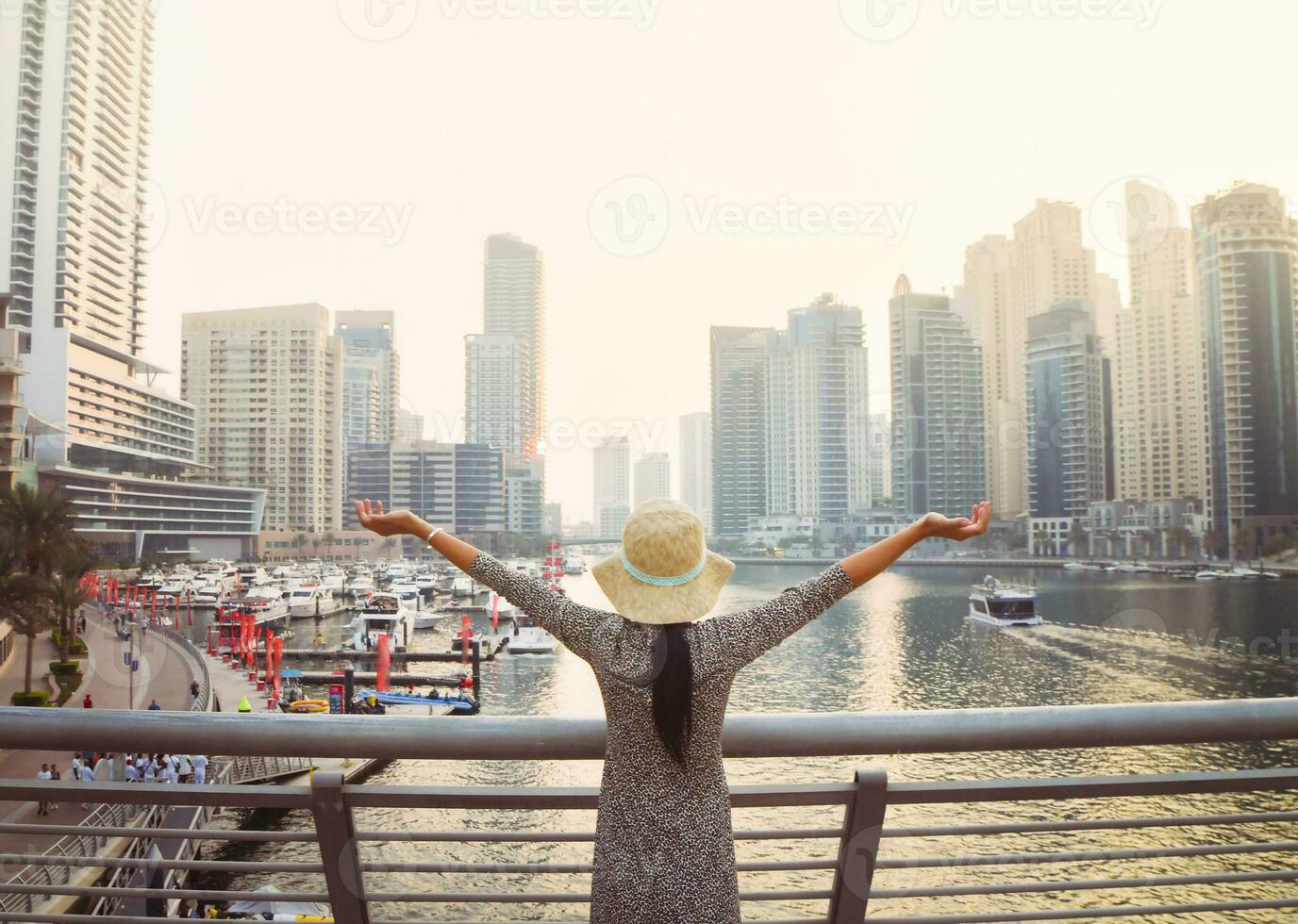 Dubai, UAE,  2022 - beautiful unrecognizable tourist woman in fashionable summer dress enjoy in Dubai marina in UAE Luxury and comfortable tourism season in UAE. photo