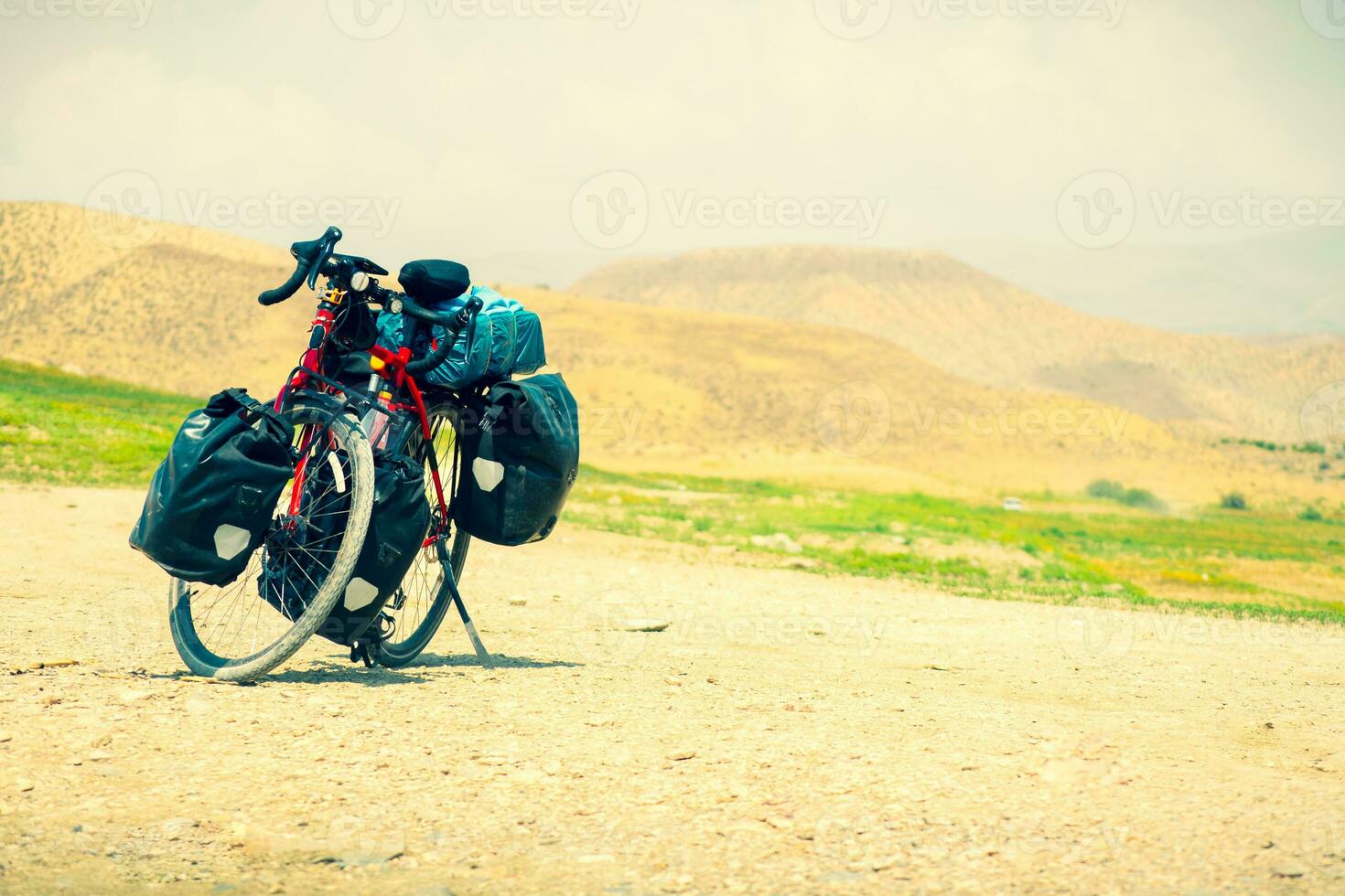 Touring bicycle stand on scenic gravel road in nature. Fully loaded touring machine with copy space background photo