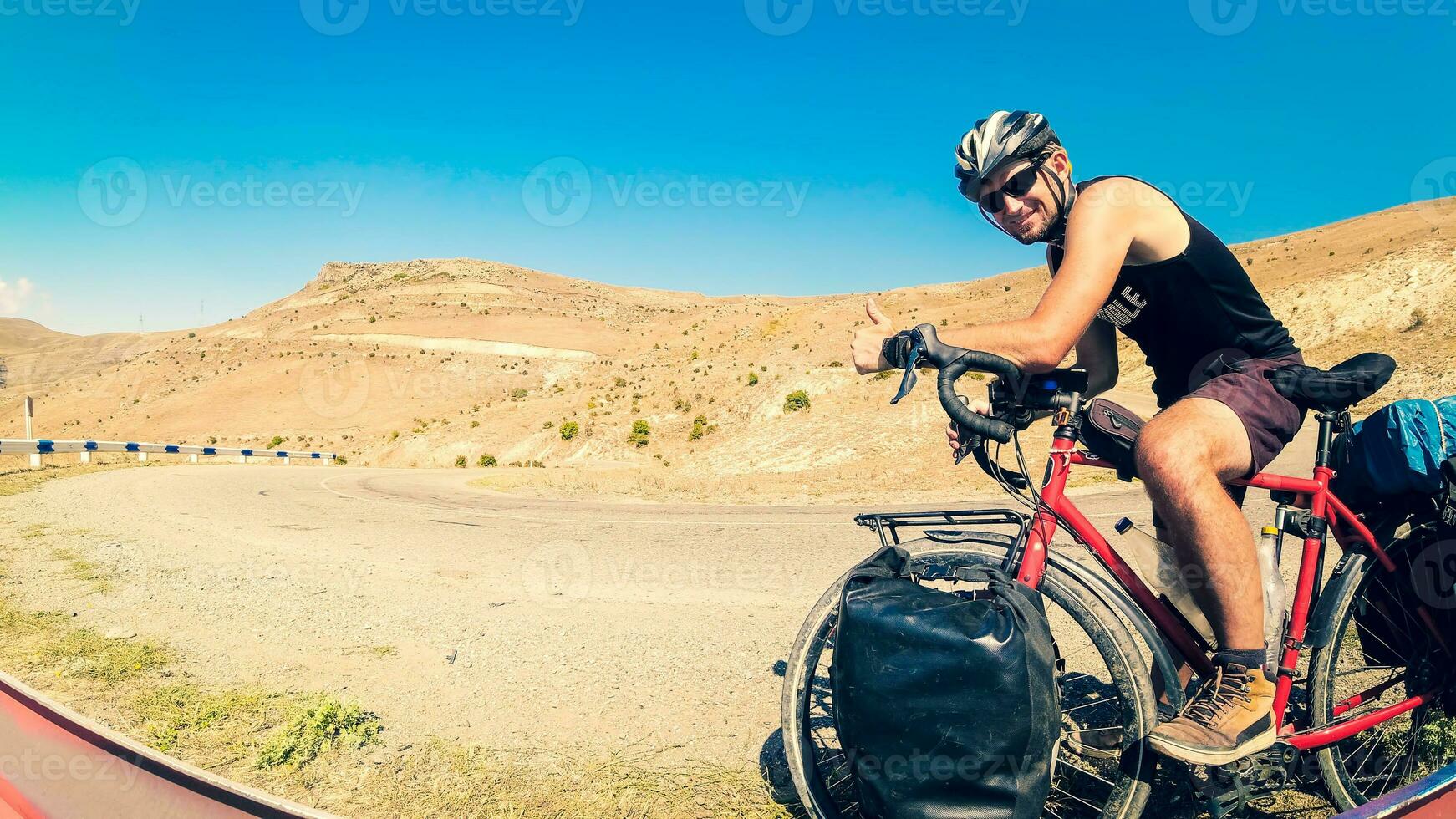 Caucasian male person stand by bicycle solo touring in tranquil countryside fully loaded with bags outdoors in summer heat. Creative ecological travel concept photo