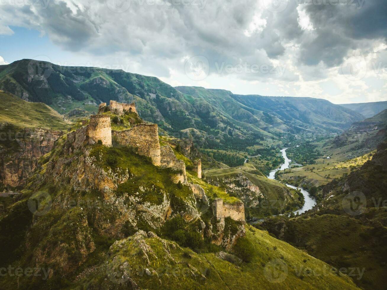 Aerial view historical Tmogvi fortress ruins with old wall on hilltop and church remains in scenic valley in summer photo
