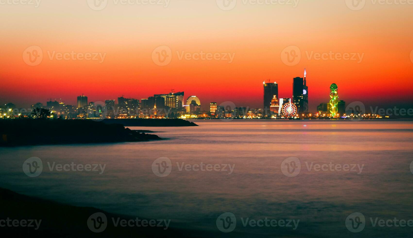 Stunning beautiful Batumi waterfront in Adjara, Georgia. Modern Architecture In Seafront Promenade In Night Or Evening Illuminations, Illuminated Resort Town Cityscape Skyscrapers photo