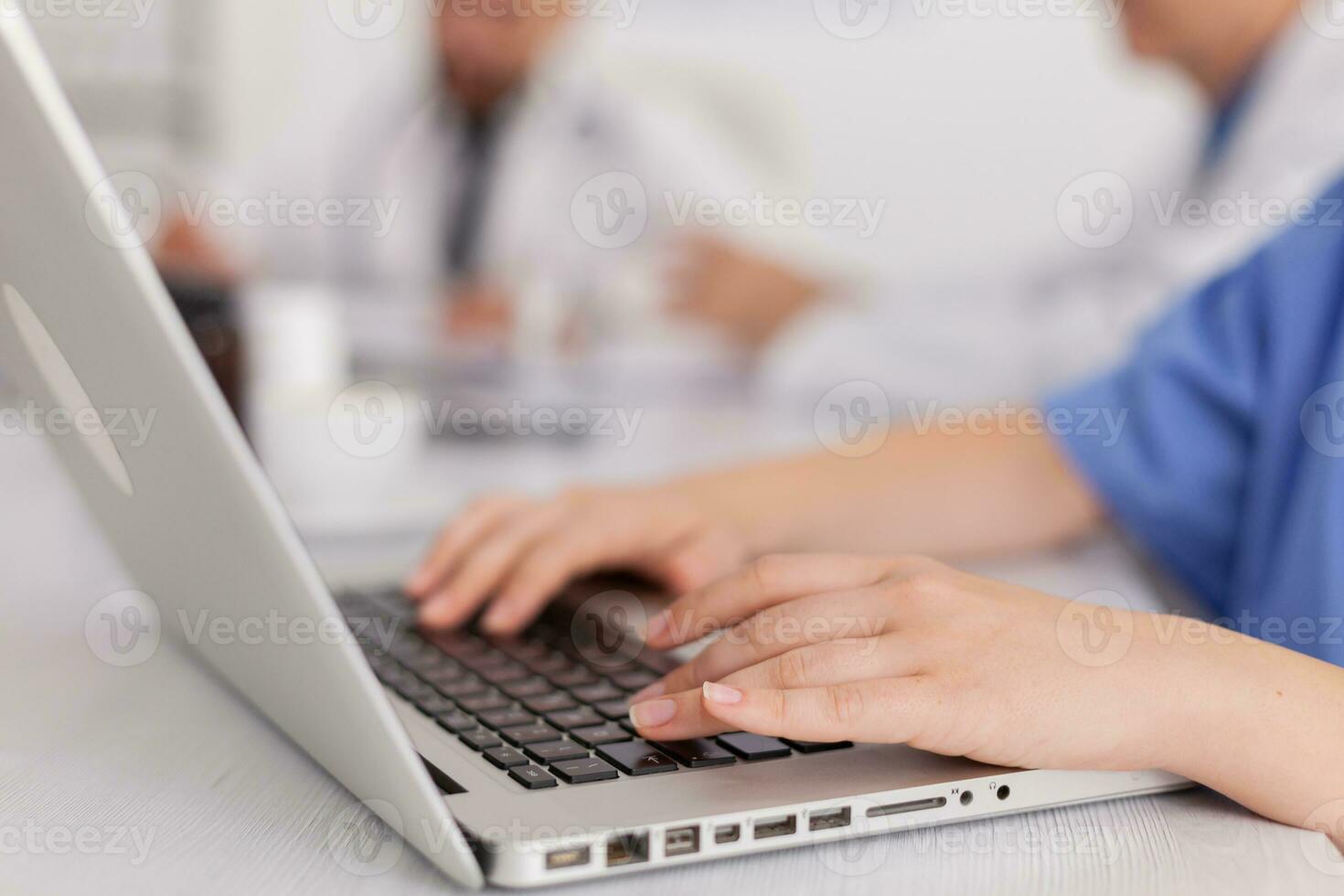 Closeup of therapist asisstant hands working at healthcare treatment typing sickness pill medication on laptop computer sitting at desk in meeting room. Physician nurse diagnosing patient disease photo