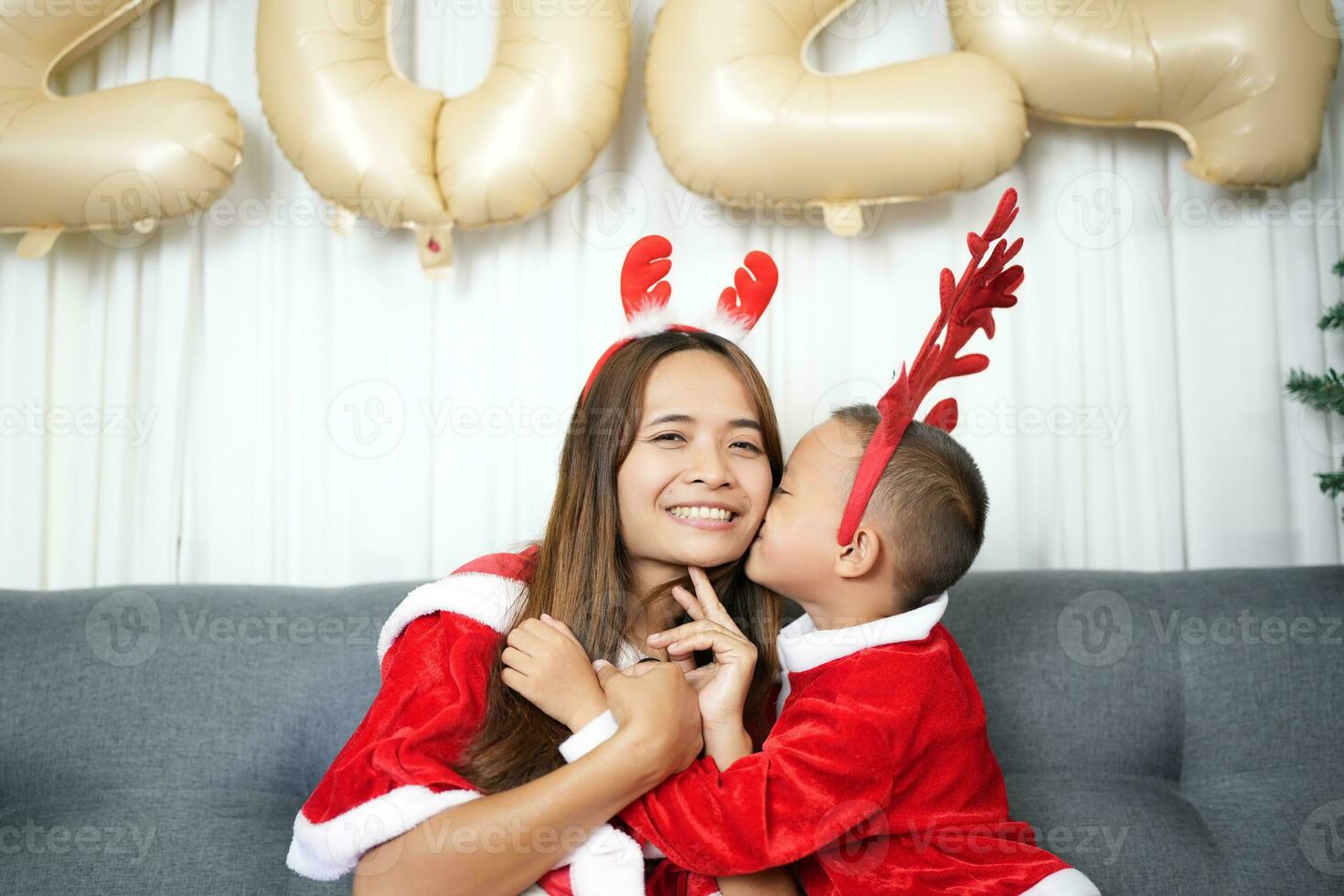 Merry Christmas 2024 concept Mother and child decorate the Christmas tree with colorful Christmas balls. photo