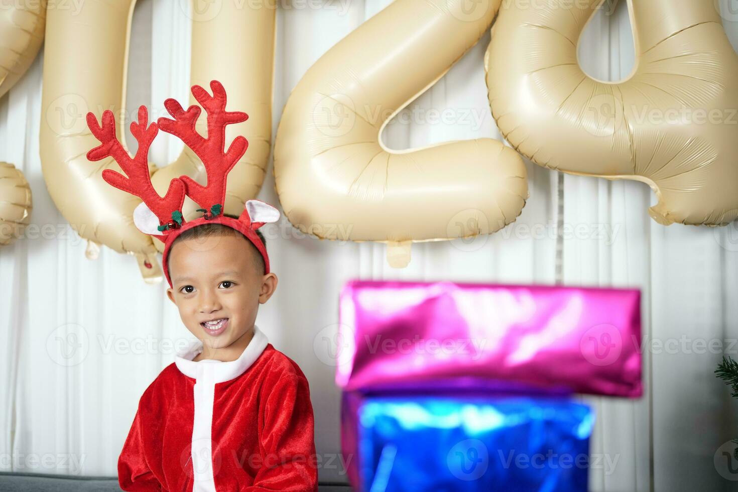 Merry Christmas 2024 concept Boy receives a gift from his mother at christmas photo