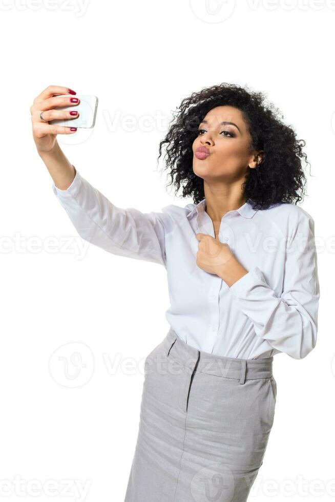 Beautiful brunette woman in classic white shirt and skirt make selfie on the phone. photo