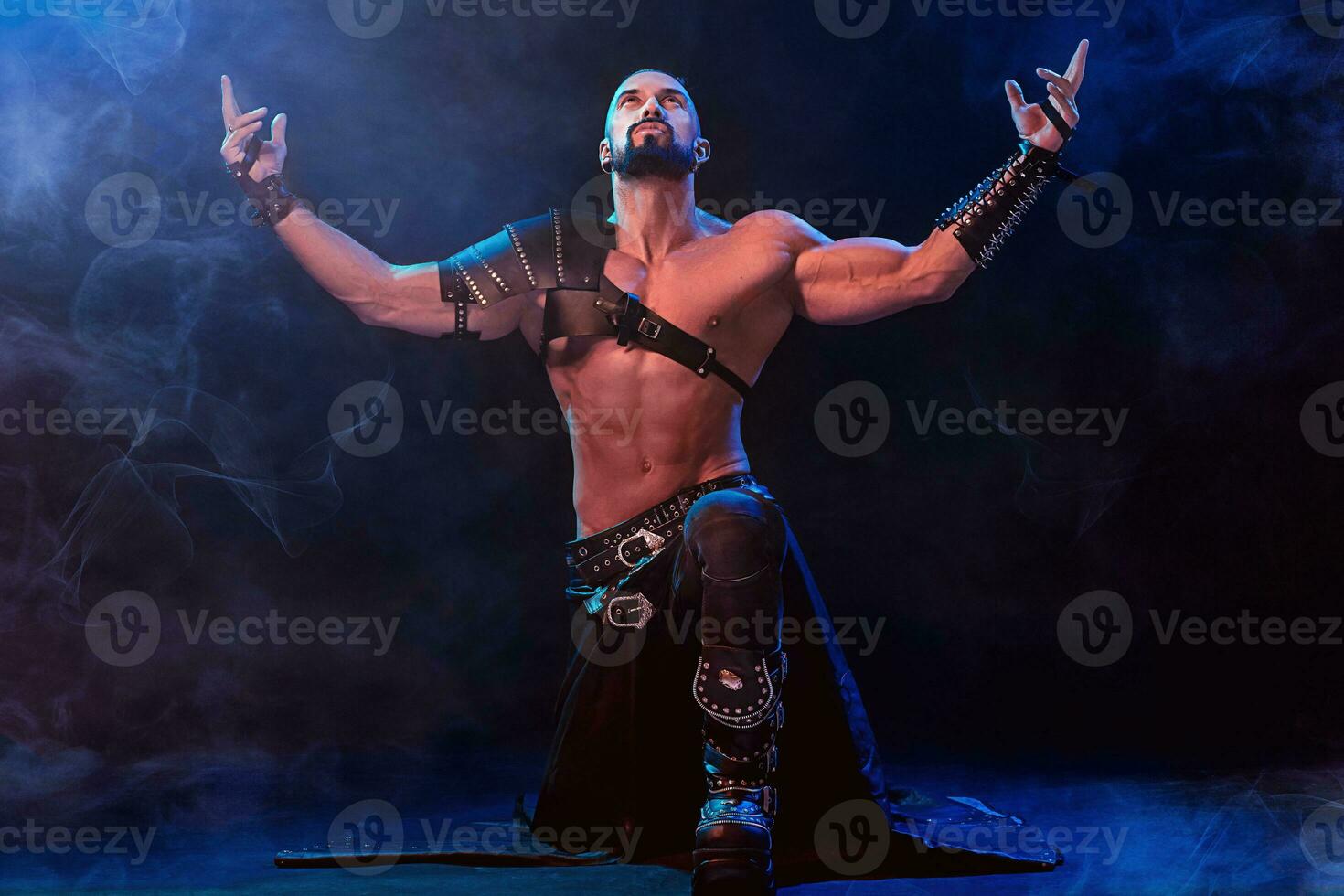 Handsome young sexy man with beautiful muscular chest in interesting costume on the scene photo
