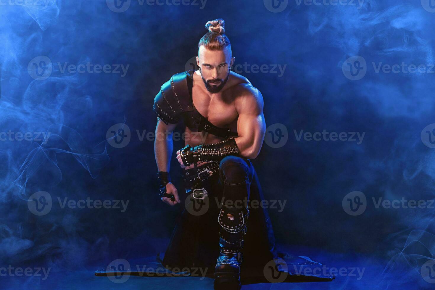 Handsome young sexy man with beautiful muscular chest in interesting costume on the scene photo