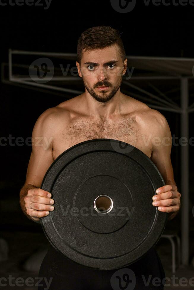 muscular carrocero hermoso hombre haciendo ejercicios en al aire libre gimnasio desnudo torso foto