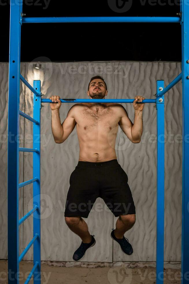 Strong young athlete is engaged in on sports field. photo