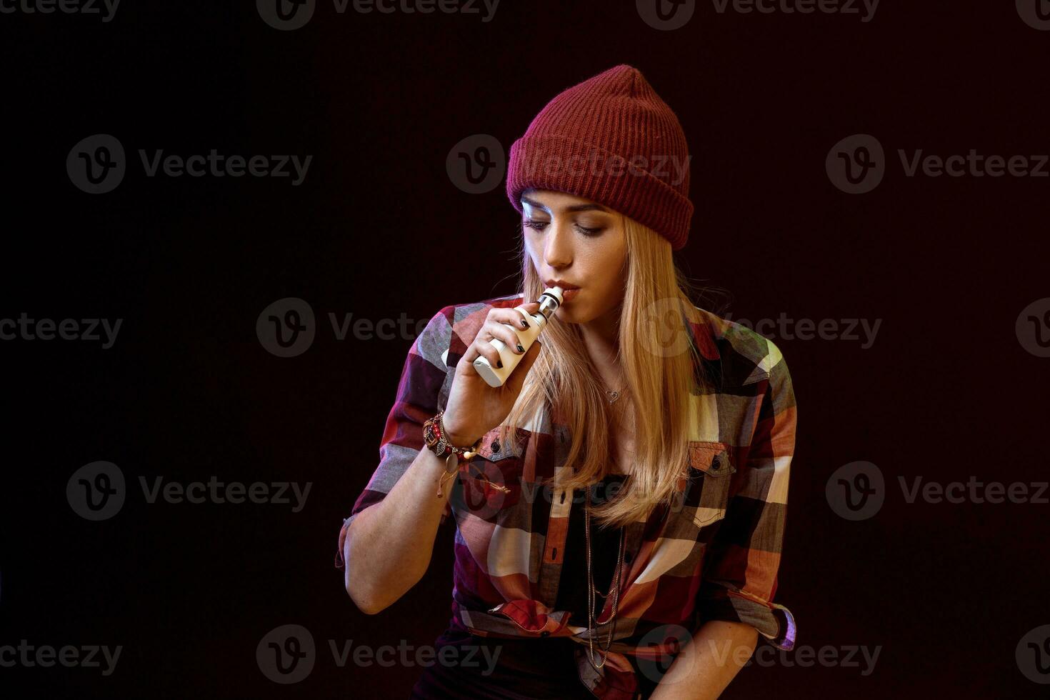 young woman smoking electronic cigarette photo