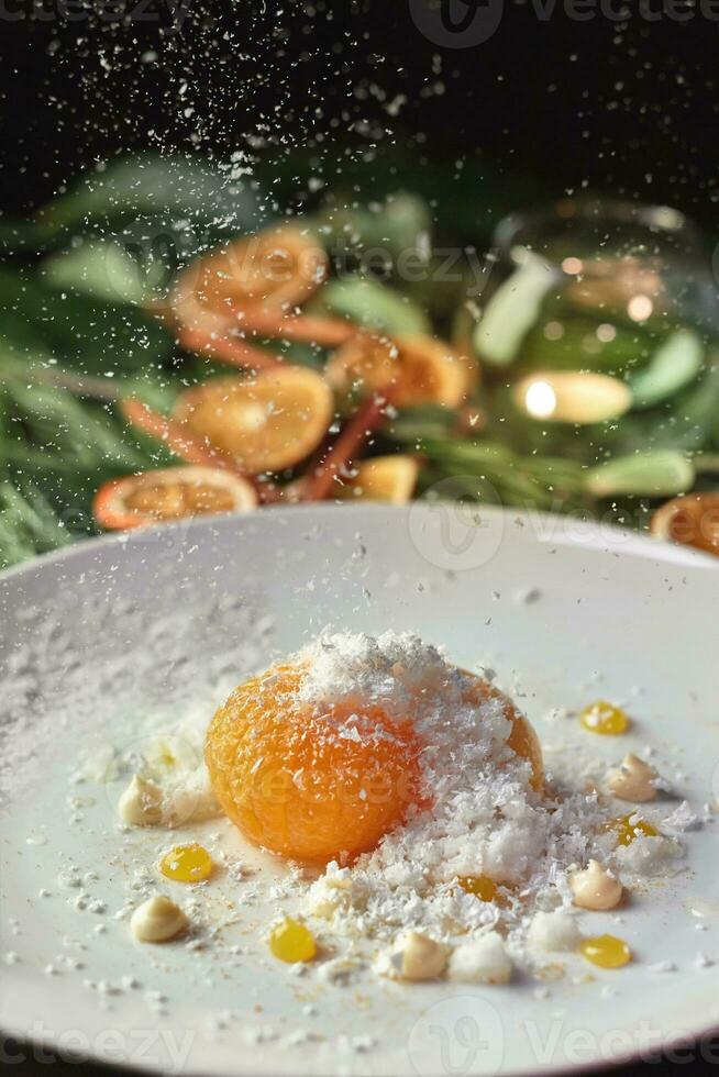 Caramelized tangerine with coconut flakes on background with Christmas decorations photo