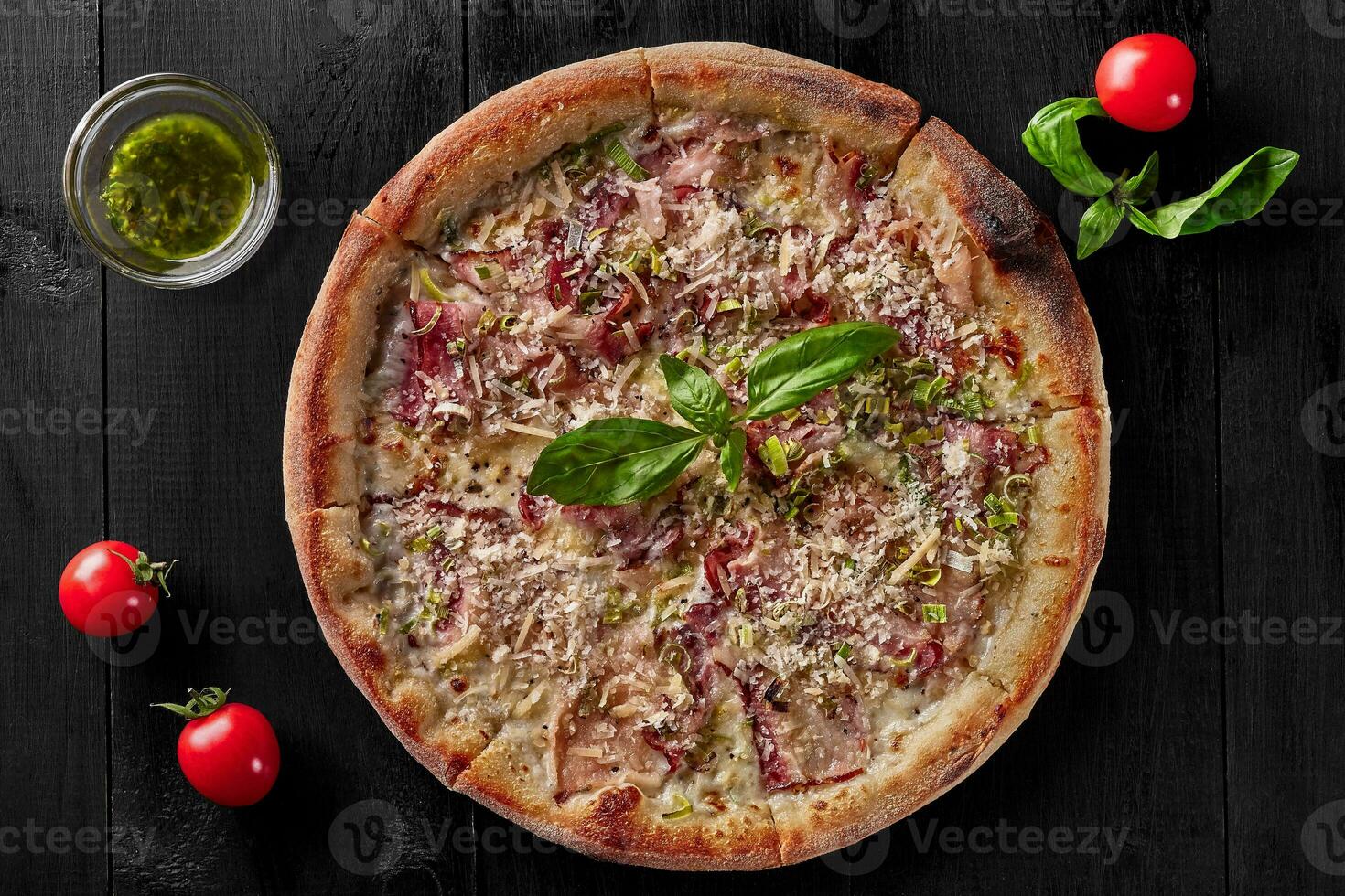 Pizza with cream sauce, mozzarella, bacon, leek and parmesan photo