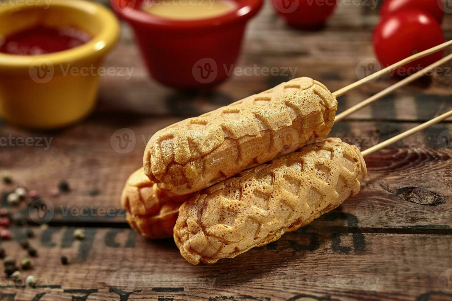 Corn dogs on skewers on rustic wooden surface photo