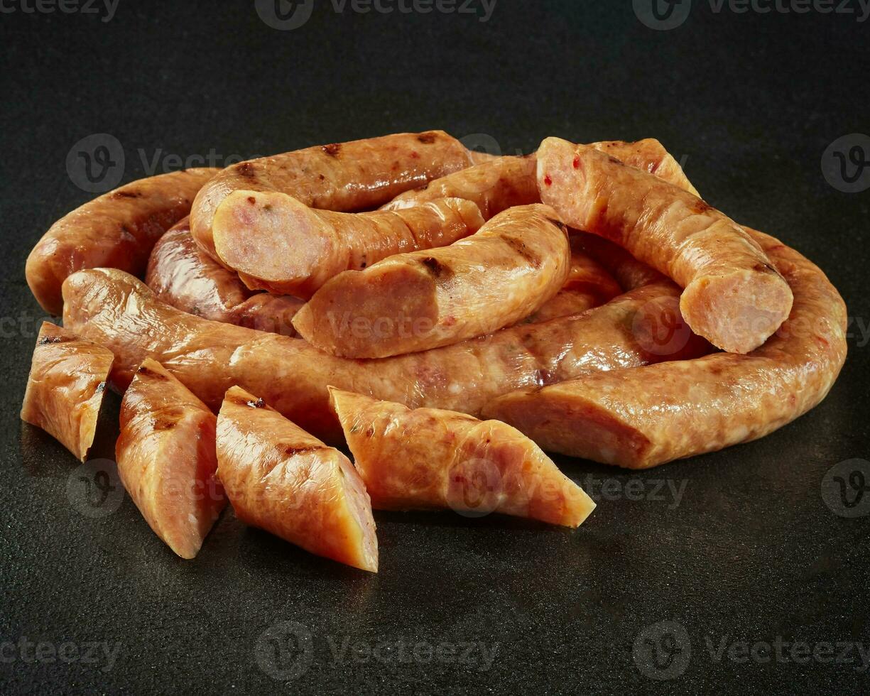 Sliced homemade chicken sausage in natural casings on black background photo