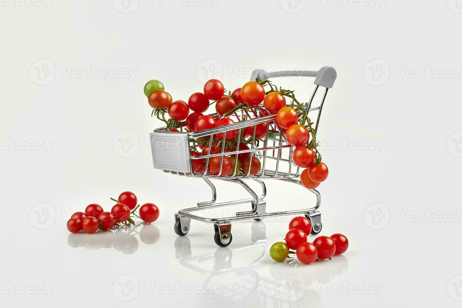 mini compras carro lleno con Cereza tomates en blanco antecedentes foto